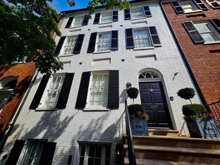 a building with black shutters and stairs