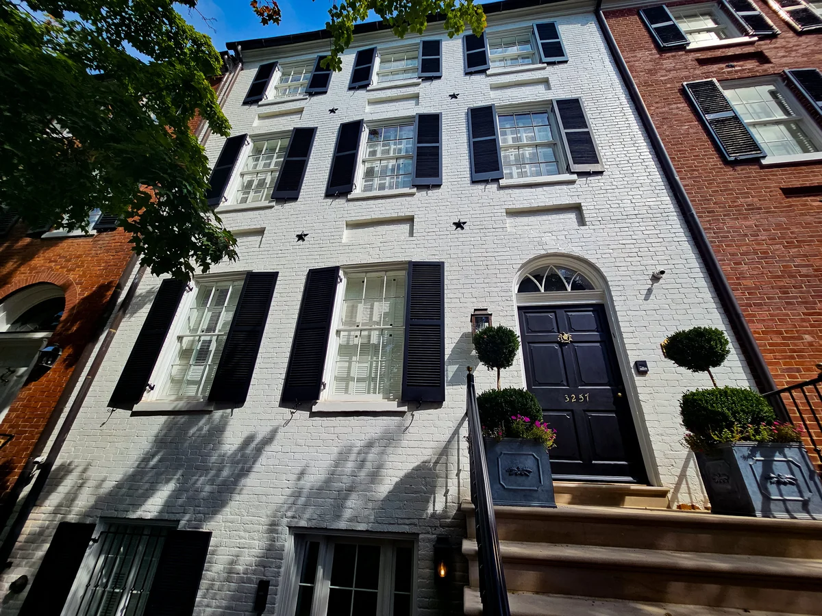 a building with black shutters and stairs